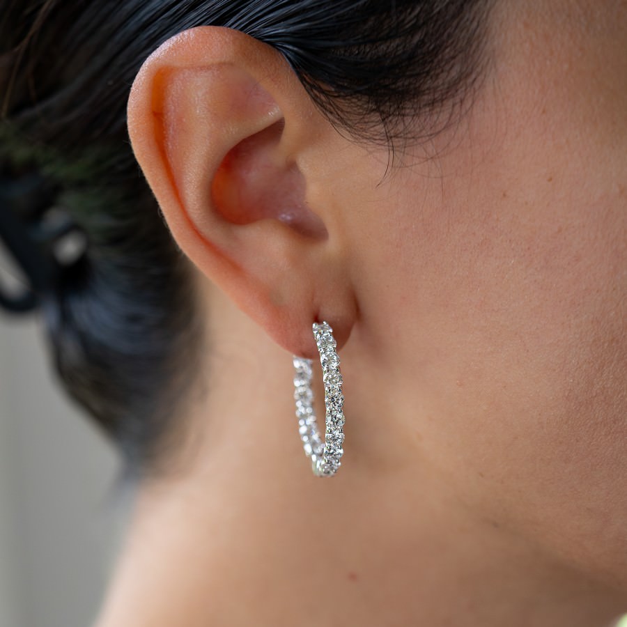 Side profile of 23.5 mm diamond huggie earrings showing hinged click clasp