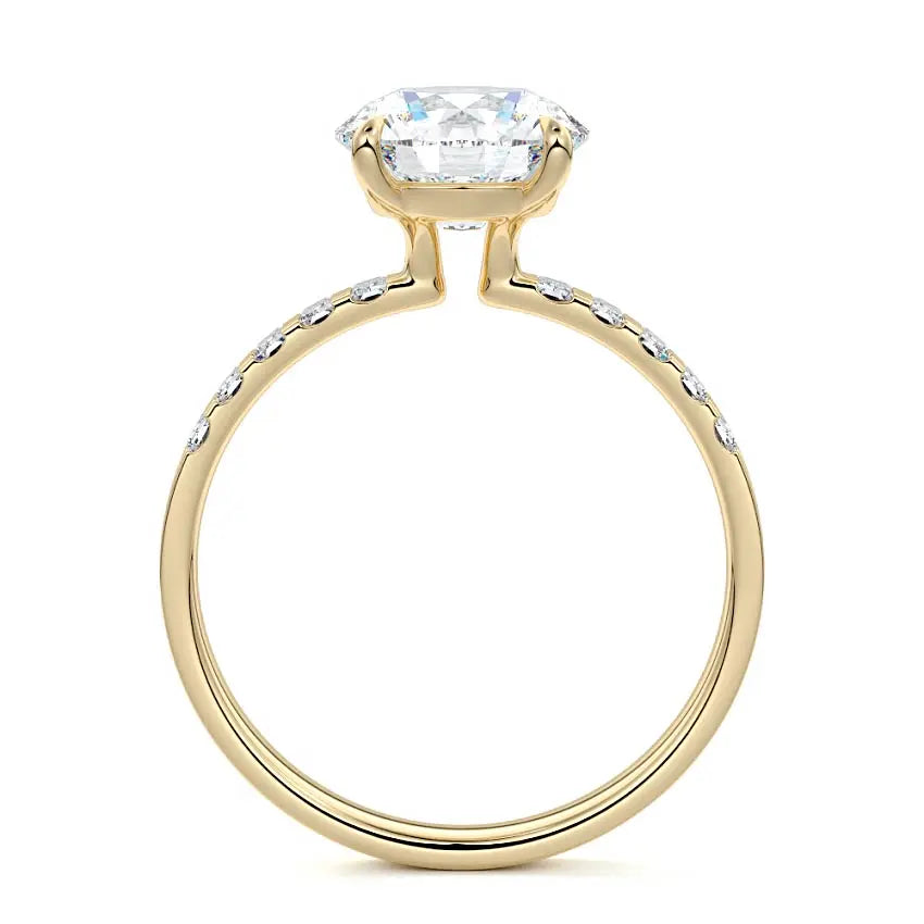 Round cut engagement ring with emerald cut side stones in 18K yellow gold by Nura Lab