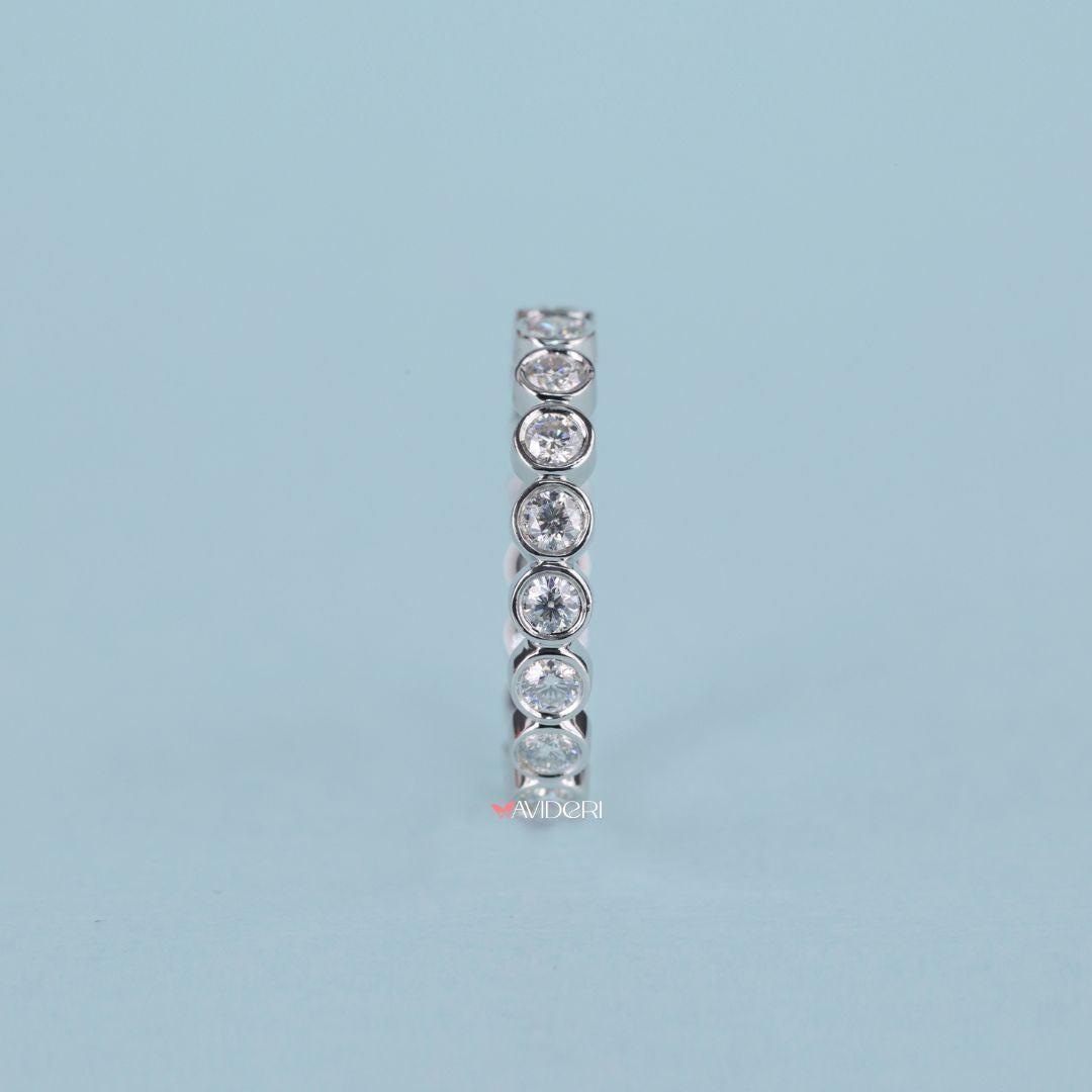 Round cut moissanite sparkles brilliantly in a clean, timeless design.
