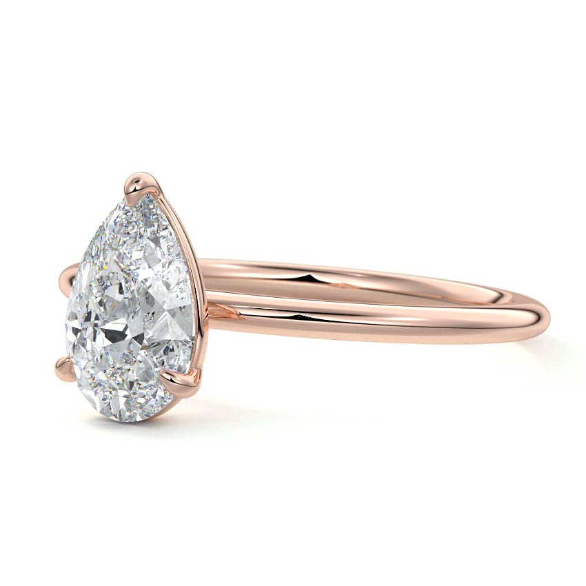 Rose gold ring with a pear-shaped diamond on a white background
