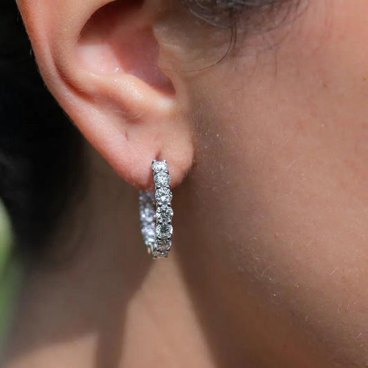 Model wearing 14K white gold 15mm lab-created diamond huggie earrings