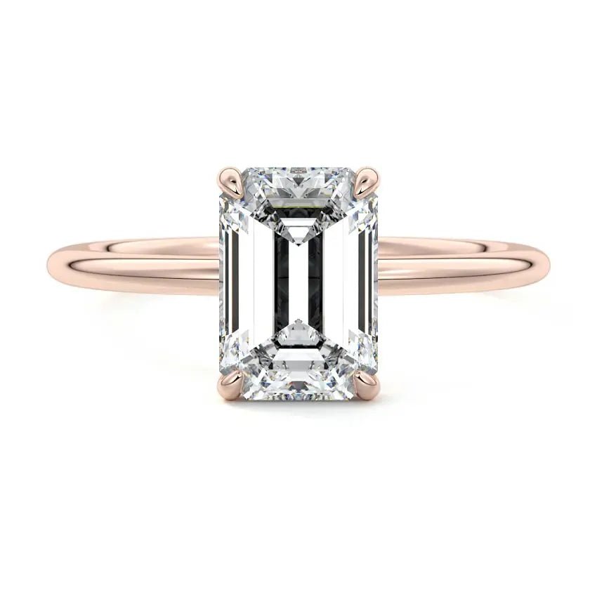 Flat lay of emerald cut lab-grown diamond ring in rose gold on marble background