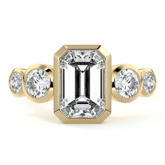 Evelina emerald cut bezel side stone lab grown diamond engagement ring in yellow gold