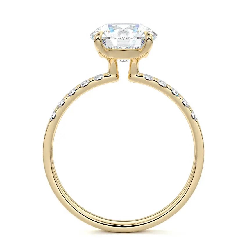 Round cut engagement ring with emerald cut side stones in 18K yellow gold by Nura Lab