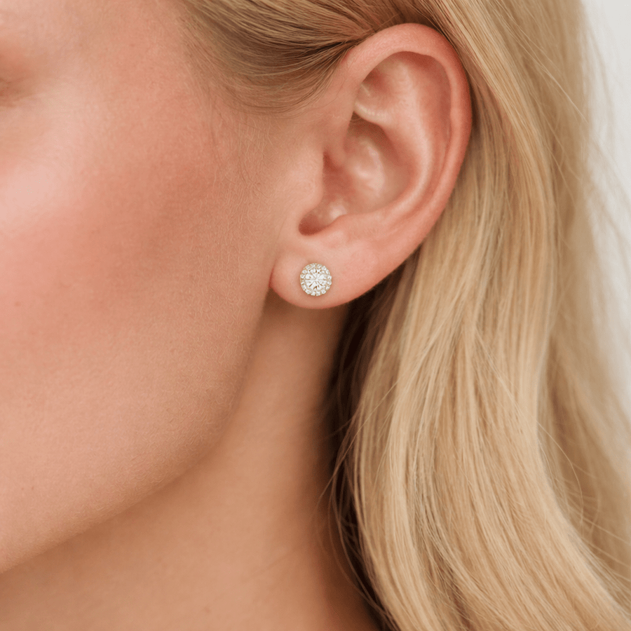 Close-up of halo moissanite stud earring in solid 14K yellow gold