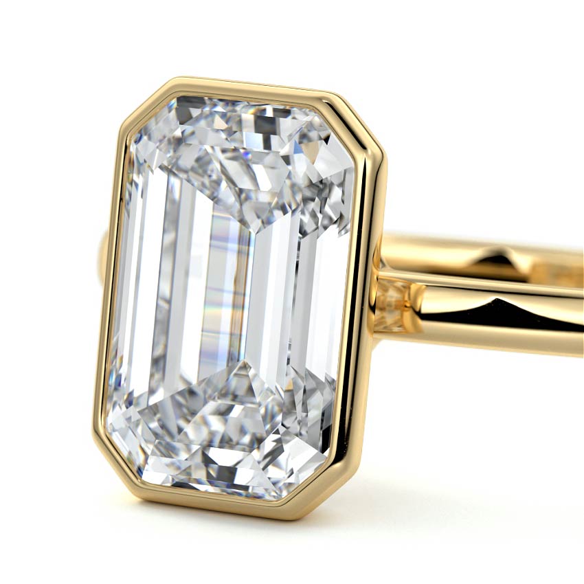 Bezel set emerald cut engagement ring in yellow gold with lab-grown diamond